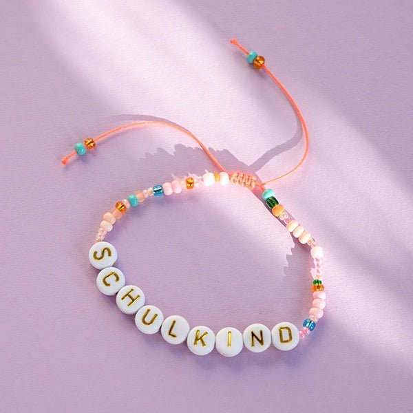 Ava & Yves Perlenarmband Schulkind in orange / rosa und goldenen Buchstaben it Säckchen in hellblau / weiss - Sausebrause Shop